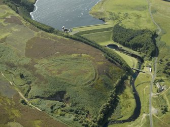 Oblique aerial view centred on the remains of the fort with the dam and reservoir adjacent, taken from the ESE.