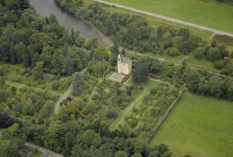 Oblique aerial view centred on the castle and garden with the suspension bridge adjacent, taken from the SE.