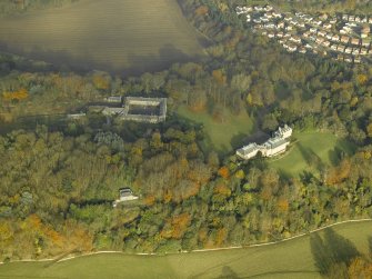 Oblique aerial view centred on the house and stable block, taken from the SSW.