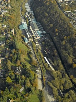 Oblique aerial view centred on the mill and chimney stack, taken from the NNW.