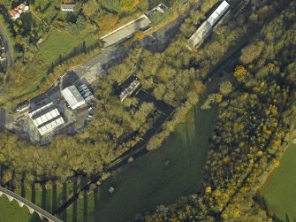 Oblique aerial view centred on the mill with the railway viaduct adjacent, taken from the SSW.