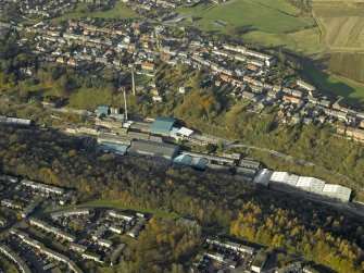 Oblique aerial view centred on the mill and chimney stack, taken from the ENE.