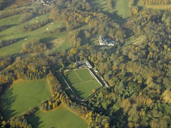 Oblique aerial view centred on the walled garden and stables with the house adjacent, taken from the SE.