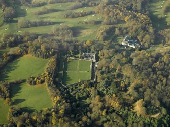 Oblique aerial view centred on the walled garden and stables with the house adjacent, taken from the ESE.