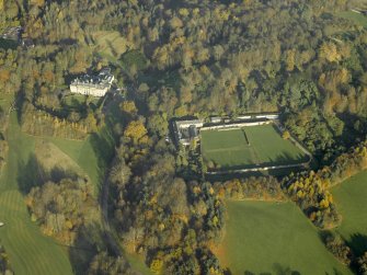 Oblique aerial view centred on the house, walled garden and stables, taken from the SE.