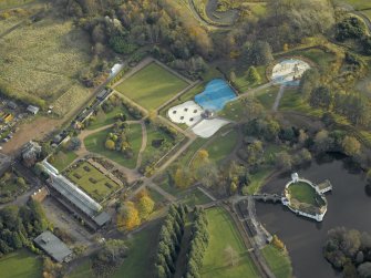 Oblique aerial view centred on the walled garden with the ornamental lake and island adjacent, taken from the NW.