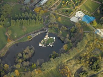 Oblique aerial view centred on the ornamental lake and island with the walled garden adjacent, taken from the SW.