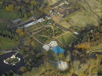 Oblique aerial view centred on the walled garden with the ornamental lake and island adjacent, taken from the SSW.
