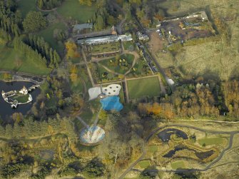 Oblique aerial view centred on the walled garden with the ornamental lake and island adjacent, taken from the S.