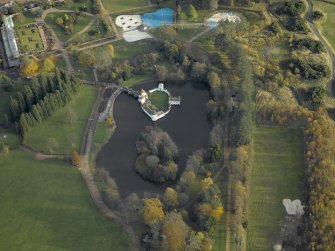 Oblique aerial view centred on the ornamental lake and island with the walled garden adjacent, taken from the WNW.