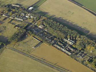 Oblique aerial view centred on the former hospital with East Fortune farmstead adjacent, taken from SE.