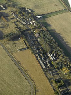 Oblique aerial view centred on the former hospital and First World War military camp with East Fortune farmstead adjacent, taken from ESE.