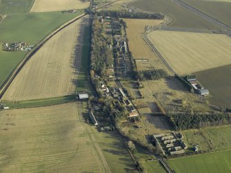 General oblique aerial view centred on the former hospital with East Fortune farmstead adjacent, taken from W.