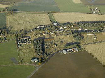 Oblique aerial view centred on the W end of the former hospital with East Fortune farmstead adjacent, taken from S.