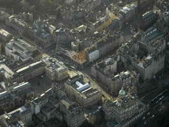Oblique aerial view centred on new construction work at the junction of High Street and George IV Bridge, taken from the NE.