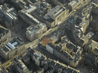 Oblique aerial view centred on new construction work at the junction of High Street and George IV Bridge, taken from the NW.