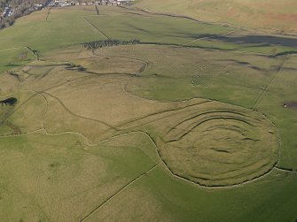 Oblique aerial view centred on the remains of the fort and linear earthwork with the remains of the linear earthwork and pit-alignment adjacent, taken from the SW.