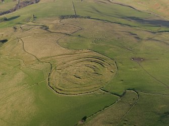 Oblique aerial view centred on the remains of the fort and linear earthwork, taken from the S.