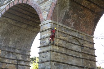Detail of Newbattle Viaduct from NE showing drill operator abseiling whilst test drilling lower pier of viaduct