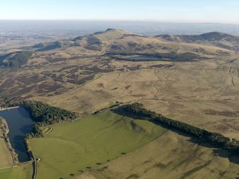 General oblique aerial view centred on the remains of rig and furrow cultivation on the the NW-facing slopes of the Pentland Hills with the remains of a fort adjacent, taken from the WNW.