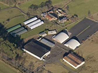 Oblique aerial view centred on the technical area including the aircraft hangars with the farmsteading adjacent, taken from the SW.
