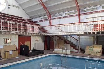 Interior. Swimming pool, view of NW staircase leading to spectator balcony