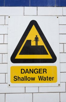 Interior. Swimming pool, detail of warning sign for shallow water