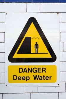 Interior view of swimming pool and detail of warning sign for deep water, IQRA Academy, Glasgow.