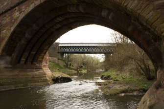 View looking through arch of road bridge to N