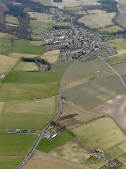 General oblique aerial view centred on the field boundaries with the town adjacent, taken from the ESE.