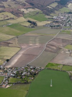 General oblique aerial view centred on the field boundaries with the town and village adjacent, taken from the ENE.