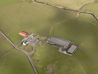 Oblique aerial view centred on the remains of the farmstead/grange with the later farmstead adjacent, taken from the SE.