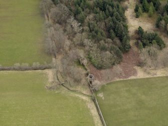 Oblique aerial view centred on the remains of the prisoner-of-war camp with The Temple adjacent, taken from the WNW.