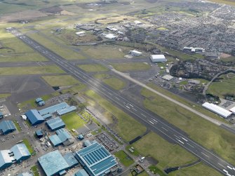 Oblique aerial view centred on the airport with the aircraft factory adjacent, taken from the NNW.