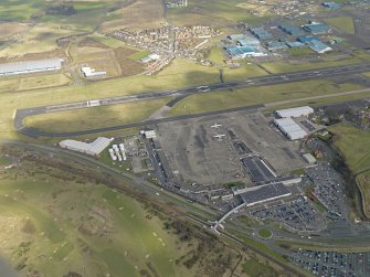 Oblique aerial view centred on the airport terminal buildings with the railway station adjacent , taken from the WSW.