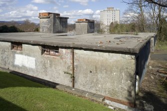 General view over roof of S main building showing water tanks on both flat roofed structures from SSE.