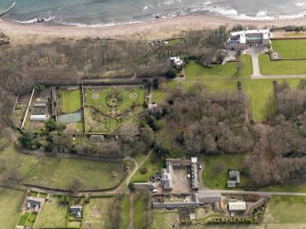 Oblique aerial view centred on the walled garden and orangery with the home farm, cottages, houses and tower-house adjacent, taken from the NW.