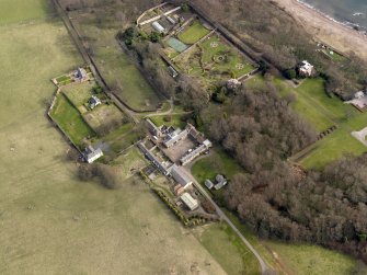Oblique aerial view centred on the home farm with the cottages, houses and walled garden and orangery adjacent, taken from the W.