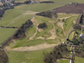 Oblique aerial view centred on the golf course with the country house, dovecot, lodge, cottage and stable adjacent, taken from the NE.