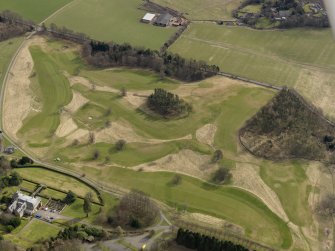 Oblique aerial view centred on the golf course with the country house, dovecot and lodge adjacent, taken from the NW.