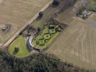 Oblique aerial view centred on the walled garden and estate cottage, taken from the NW.