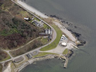 Oblique aerial view centred on the South Lodge, with the pier and quay adjacent, taken from the NW.