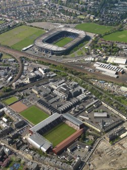 Oblique aerial view of Edinburgh centred on the Tynecastle Park football stadium with the North British Distillery adjacent and Murrayfield Stadium in the background, taken from the SE.
