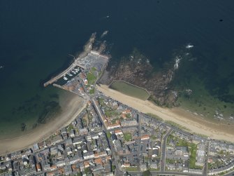 General oblique aerial view centred on the N part of North Berwick, taken from the S, showing the harbour and open air swimming pool.