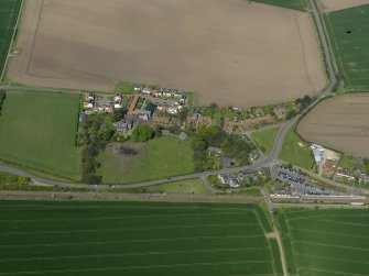Oblique aerial view centred on the village with the railway station adjacent, taken from the SSE.