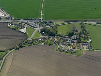 Oblique aerial view centred on the village with the railway station adjacent, taken from the N.