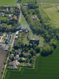 Oblique aerial view centred on the parish church with the church hall adjacent, taken from the N.
