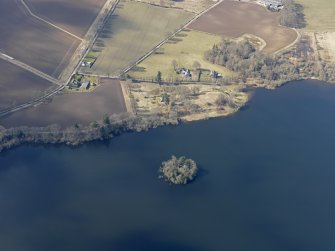 General oblique aerial view of the church and the remains of the earthwork castle, with the chapel and towerhouse on the island, taken from the E.