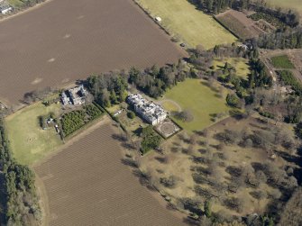 Oblique aerial view centred on the country house and stables, taken from the W.