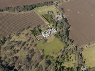 Oblique aerial view centred on the country house and stables, taken from the SE.